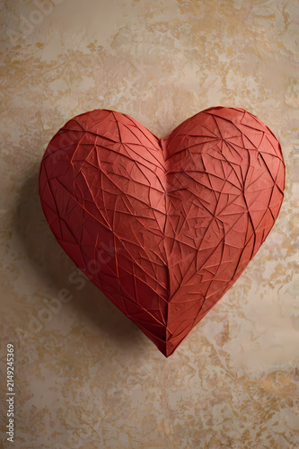 Geometric faceted red paper heart with sculpted folds on warm textured handmade paper background