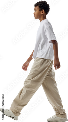 Boy walking left in profile isolated on transparent background. Concept of directional layouts, casual clothing catalogs, public space visualization.