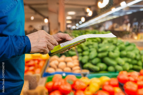 Cuadro en lienzo White man using tablet over produce, closeup hands tapping screen, green peppers