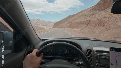 Car / SUV interior POV driving steering wheel with GPS navigation on mountain road in Salta Argentina
