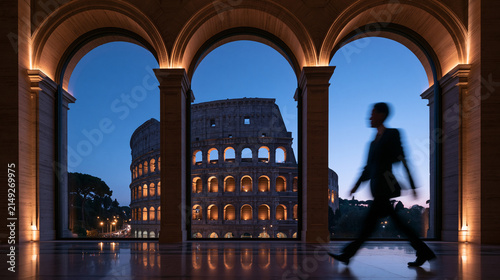 Businessman Walking Past Arched Window with View of Colosseum