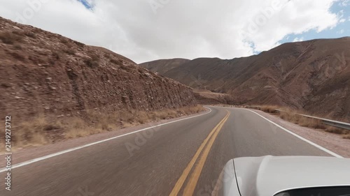 Driving POV on scenic National Route 68 in Quebrada de las Conchas Salta Argentina. Mountains, red. Hood reference.