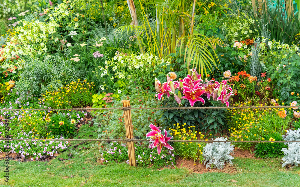 Fototapeta premium Pile of sharp wood, wooden fence posts in flower garden