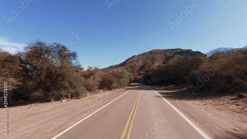 Driving POV on scenic National Route 68 in Quebrada de las Conchas Salta Argentina. Mountains, red. Hood reference.