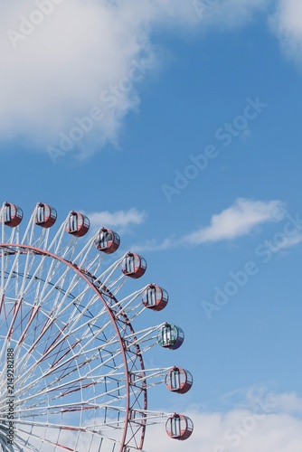 Ferris wheel against a blue sky with clouds