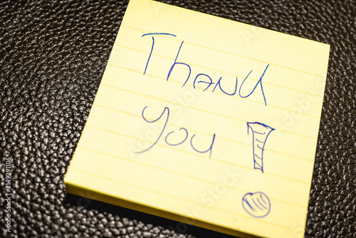 A handwritten note with the text Thank You  on it.