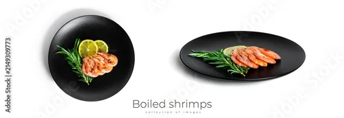 Obraz  z motywem Boiled shrimps with lemon and rosemary on a black plate isolated on a white background.