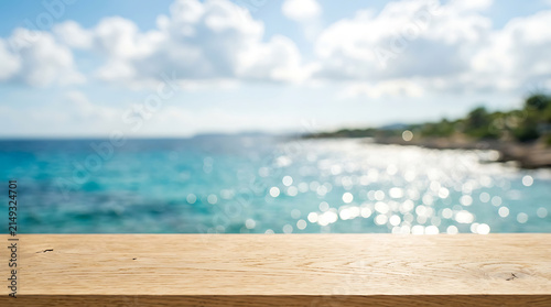 Empty wooden table surface with blurred ocean view background