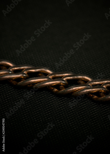 Macro Close-up of a Metallic Chain on a Dark Background