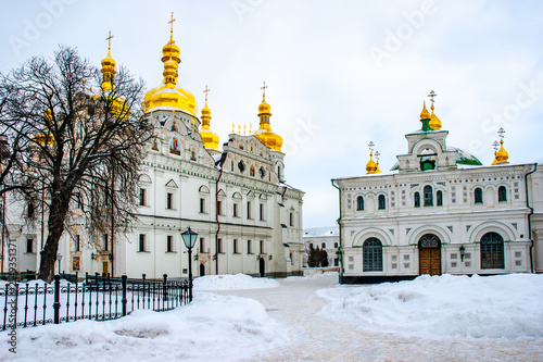 Foto Eastern Orthodox cathedral and chapel with gilded domes surrounded by snow under