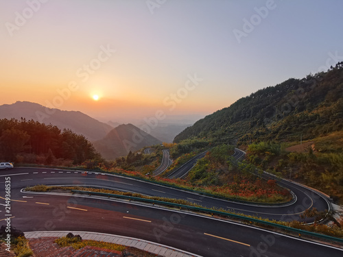 Winding mountain road with hairpin turns at sunset