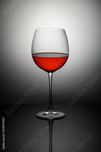 Canvas Print Elegant red wine glass capturing light in a minimalist setting showcasing its