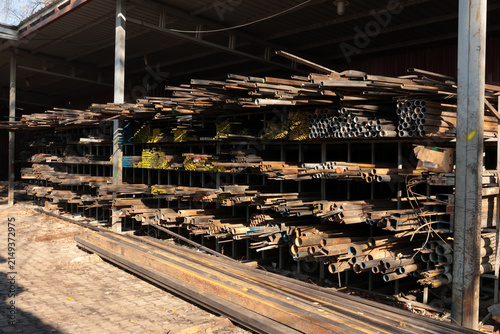 Wide view of industrial steel warehouse with stacked metal pipes, bars and profiles stored on heavy steel racks