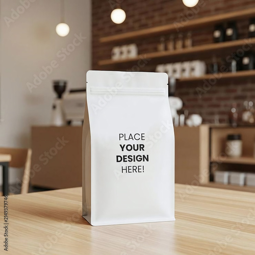 White coffee bag packaging mockup standing on a wooden cafe table with a softly blurred coffee shop interior, suitable for branding and product presentation.