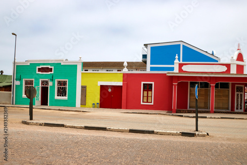 Canvastavla Mehrere farbige Gebäude mit markanten Fassaden stehen an einer breiten Straße in Swakopmund in der Region Erongo, Namibia