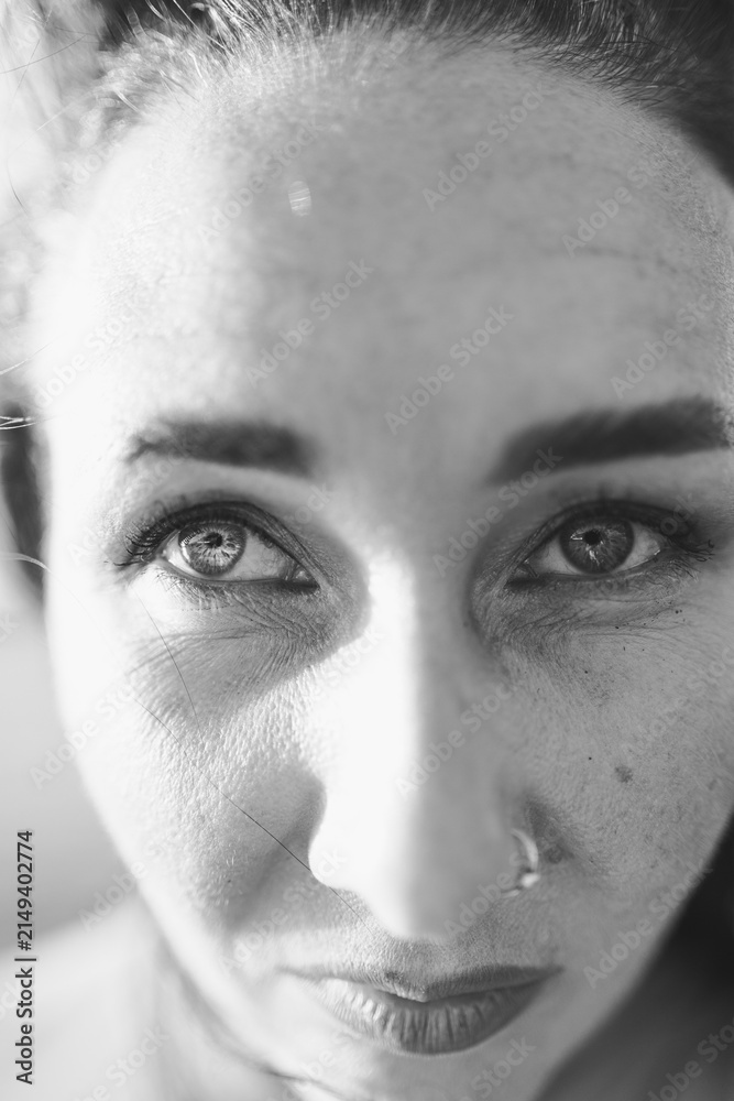 Obraz premium Close up view of a woman with intense gaze in black and white