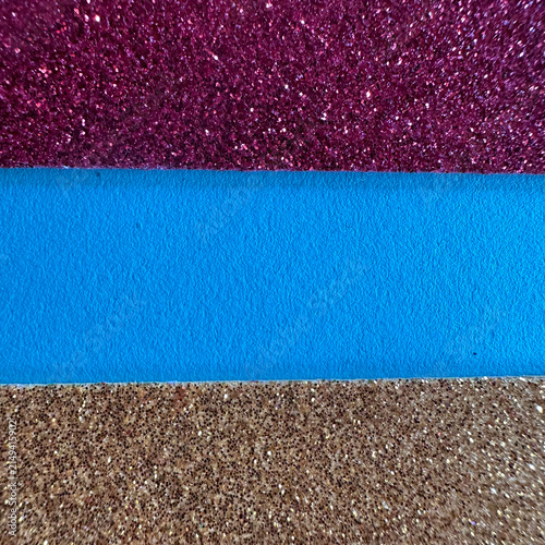 Horizontal stripes of purple glitter, blue matte, and gold glitter texture