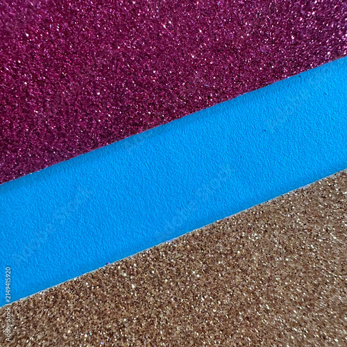 Diagonal stripes of purple glitter, blue leather, and gold glitter