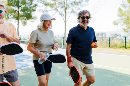 Seniors enjoying pickleball game on outdoor court