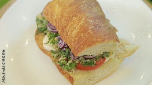 Mediterranean ciabatta sandwich served on a white plate in a kitchen