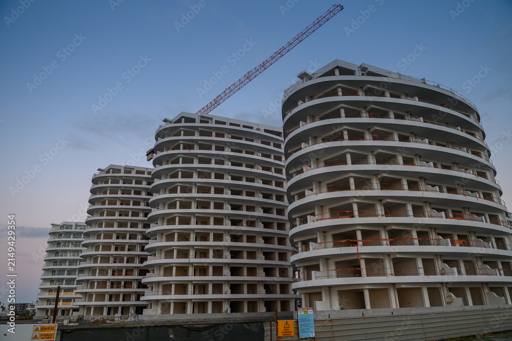Fototapeta premium Modern architecture of unfinished buildings against twilight sky in a developing urban area