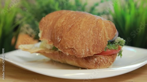 Mediterranean ciabatta sandwich served on a white plate in a kitchen