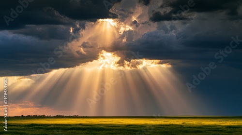 Sun rays piercing dark clouds over a peaceful field, providence and hope concept