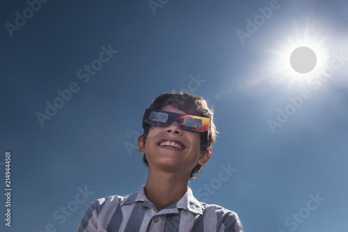 Smiling Boy Wearing Solar Eclipse Glasses Under the Sun