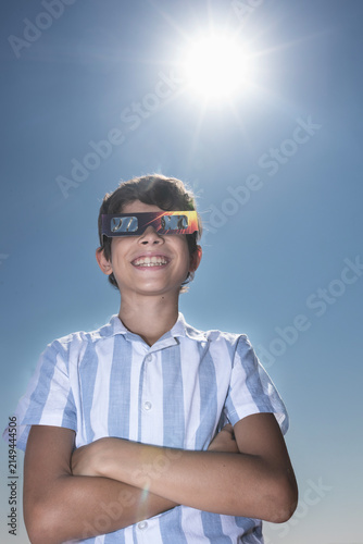 Smiling Boy Wearing Solar Eclipse Glasses Under the Sun