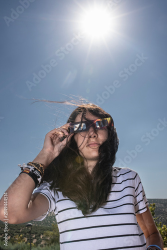 Girl Wearing Protective Glasses for a Solar Eclipse Under Bright Sunlight