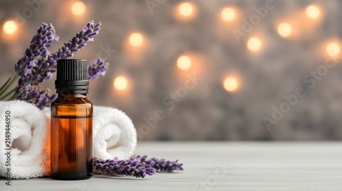 Lavender essential oil bottle and towels with lavender flowers on a blurred bokeh background