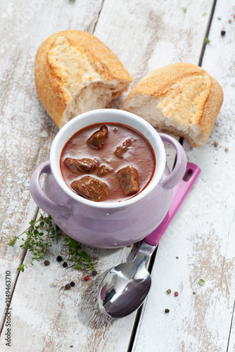 oulash soup with white bread in bowl, close up