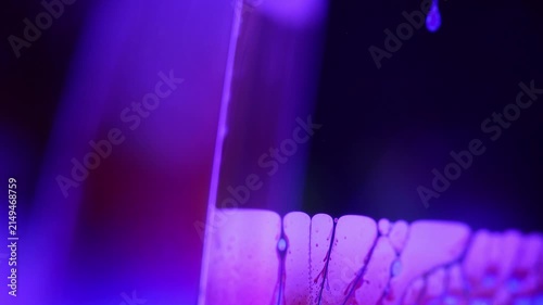 Glowing violet fluid boundary with intricate dark marble waveforms. Intense violet backlight illuminates a sharp diagonal liquid plane boundary.