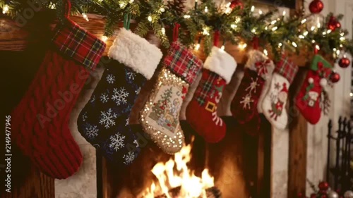 A mesmerizing slow-motion video captures cozy christmas ambiance with a crackling fireplace and beautifully adorned stockings, perfect for holiday season footage and clips.