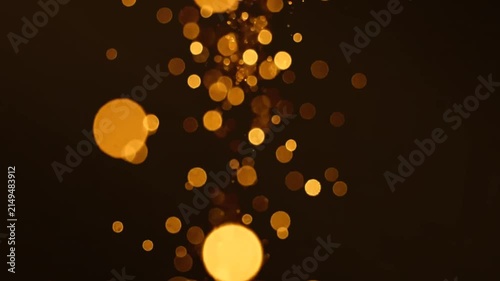 Floating golden light particles moving slowly across black background abstract cinematic backdrop motion graphic footage element for visual effects composition.