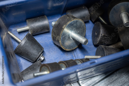 Detail of rubber vibration dampers with fittings in a blue bin.