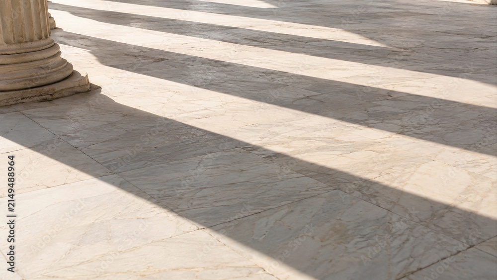Obraz premium Classical stone columns cast long diagonal shadows across veined marble floor in Greece