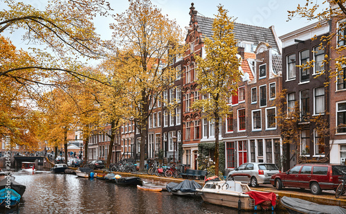 Amsterdam, Netherlands. Panoramic view of autumn Dutch city. Famous channel of Amstel river. Evening cityscape. Colorful sunset scene of famous travel destination in Europe. Romantic traveling place.