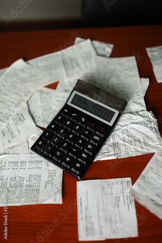 Overhead shot of a calculator displaying numbers on top of store receipts for personal finance