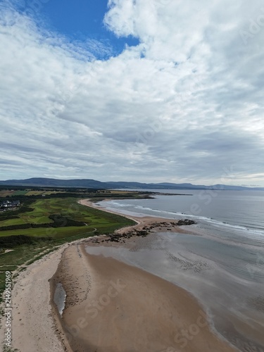 Dornoch is a historic Highland town overlooking the sea and Dornoch Firth, known for its cathedral, castle, sandy coast, and blue skies.