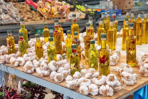 Bottled olive oil and garlic bulbs at market stall, Croatia.