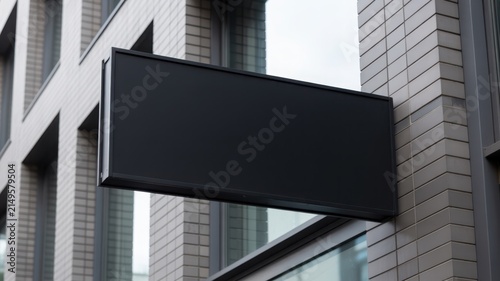 Mockup of a blank black outdoor signage board hanging on a modern building facade