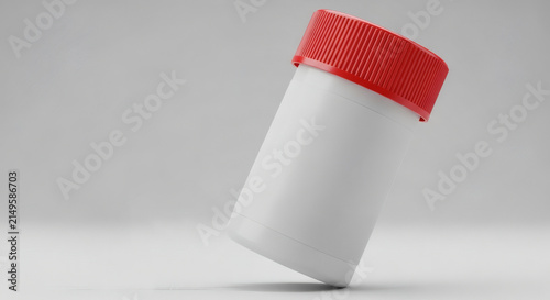 White plastic medicine container bottle with red cap on light background