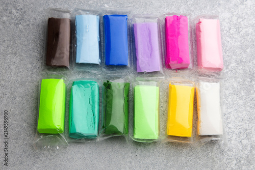 Air dry modeling clay in various colors placed on a gray surface for crafts and art projects