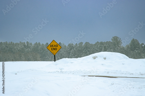 Winter Roadblock: A Yellow Dead End Traffic Sign Behind a Large Snowy Winter Snowbank