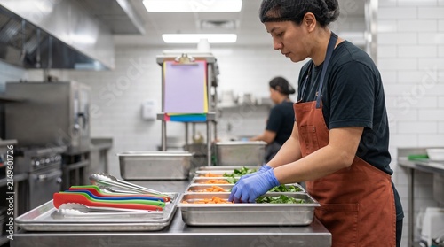 Worker organizes a dedicated school meal preparation station