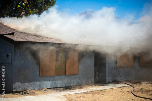 Firemen and women practicing to put out fires on an abandoned house looking at