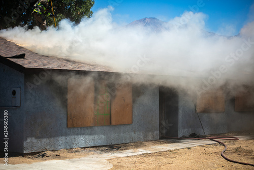 Firemen and women practicing to put out fires on an abandoned house looking at