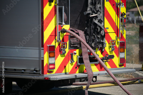 Firemen and women practicing to put out fires on an abandoned house looking at firetruck on scene at a structure fire