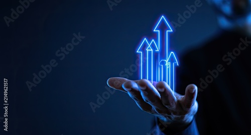 A hand holds glowing blue arrows pointing upward, signifying growth